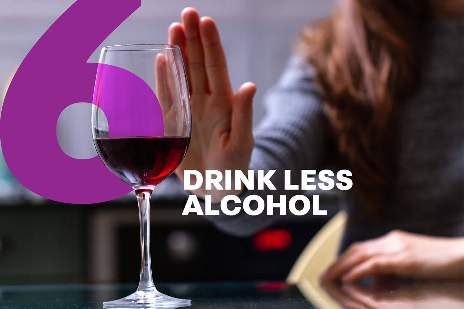 A woman with her hand out towards a glass of wine