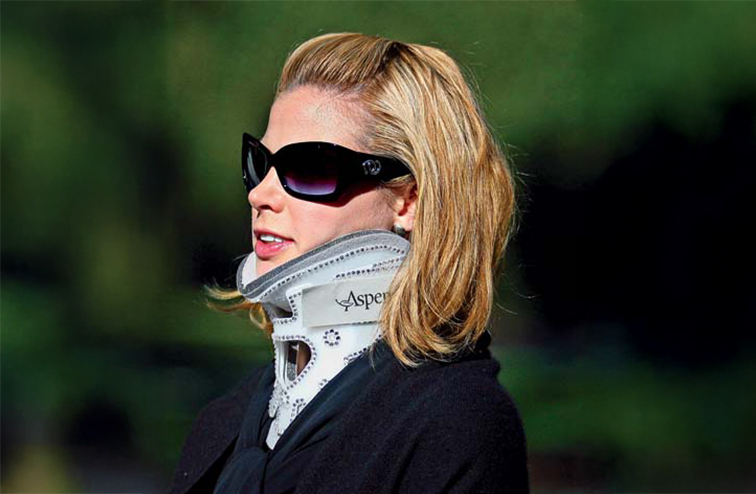 Brooke Burns wearing sunglasses and a neck brace.