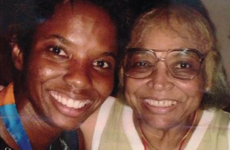 A smiling Scurry wearing her Olympic medal with her mother.