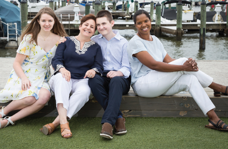 Scurry seated with her wife and two children in 2019.