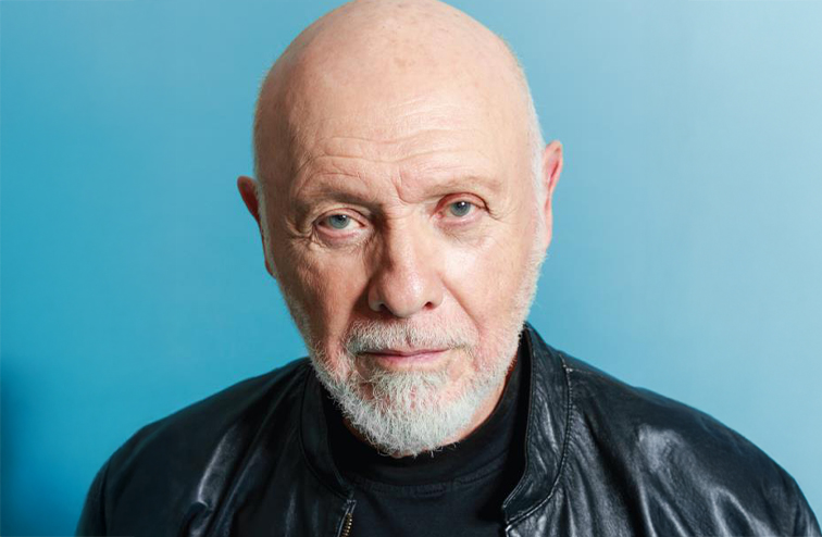 Portrait of Hector Elizondo in front of a light blue background