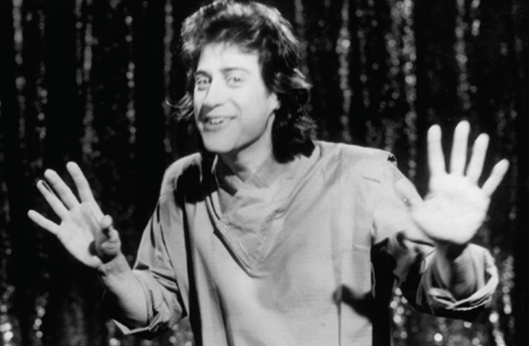 A black and white photo of Lewis during his 1985 concert, "I'm in Pain."