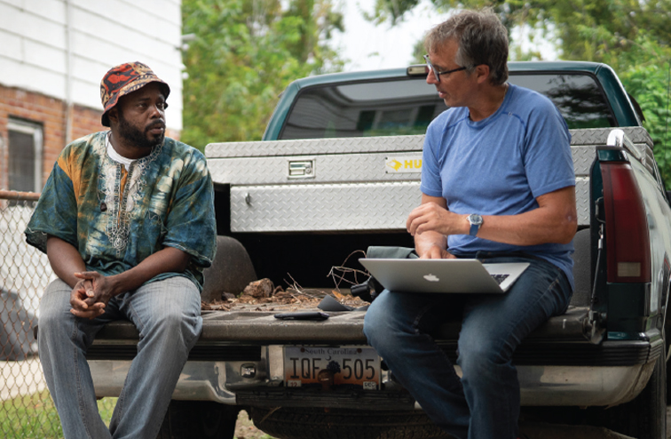 Dan Buettner learning about regional African American cuisine while sitting in the bed of a pickup truck with chef BJ Dennis