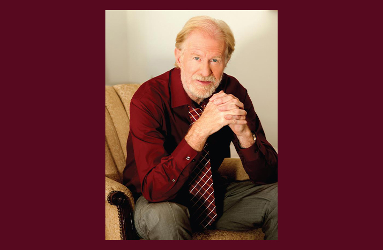 Portrait of Ed Begley Jr. in a red shirt and tie