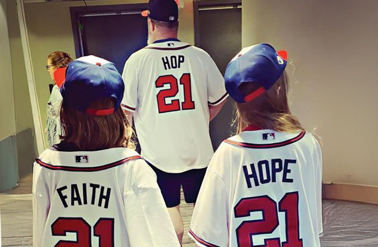 John Driskell Hopkins with his twin daughters Faith and Hope wearing Atlanta Braves baseball jerseys
