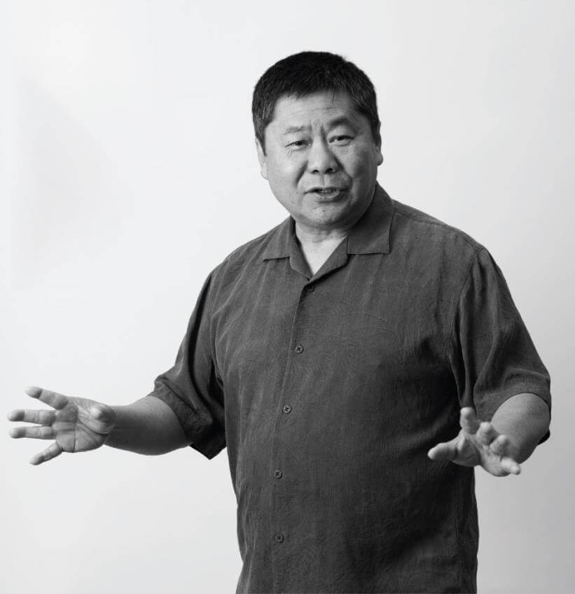 Black and white photo of Brason Lee wearing a short sleeve button up and hands stretched out