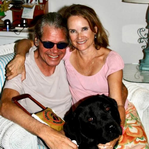 A photograph of Audrey Stafford and her husband Jeff Golub with their dog. 